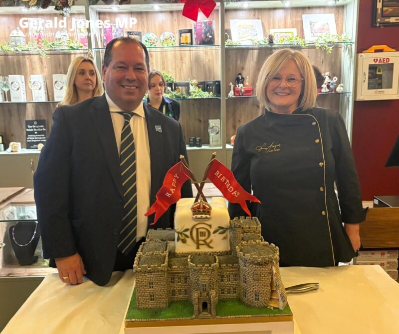 Image of Gerald Jones MP with the cake and baker.